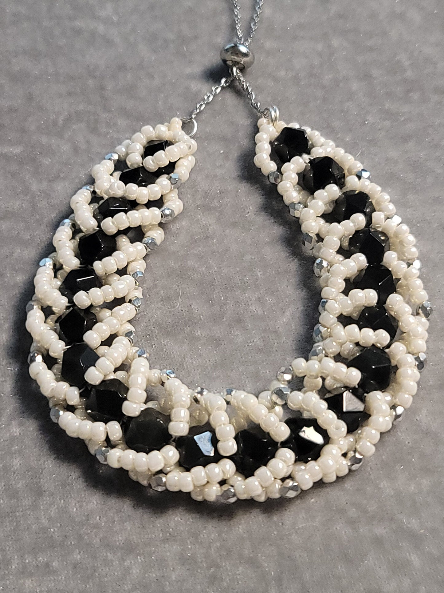 Adjustable bead woven black onyx bracelet with pearlescent beads - silver tone.
