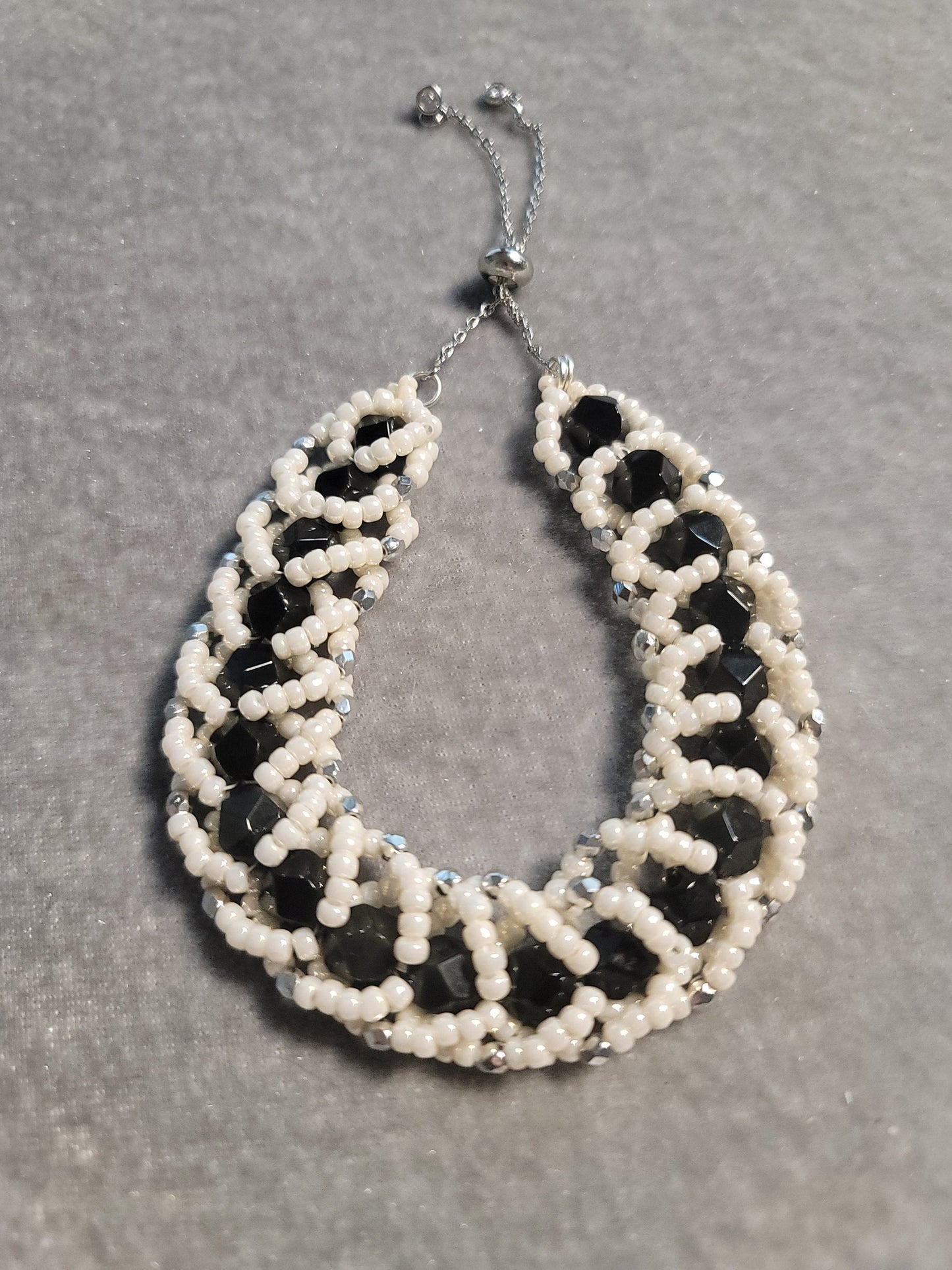Adjustable bead woven black onyx bracelet with pearlescent beads - silver tone.